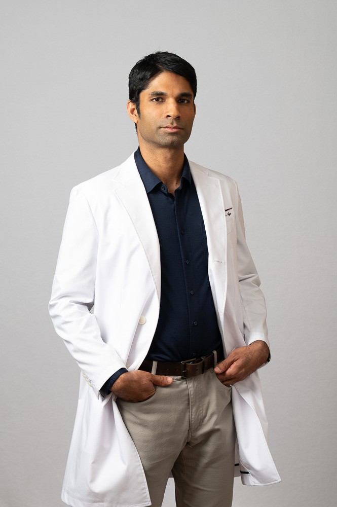 Anant Vinjamoori, MD, MBA, in a white coat
